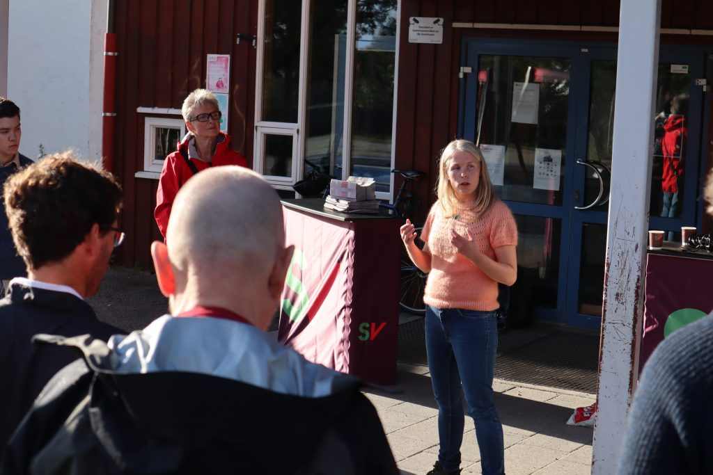 Bilde: Kirsti Bergstø snakker foran en gruppe mennesker på SV arrangement